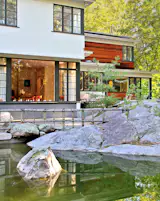 Both the existing architecture and the new addition feature extensive glazing and corner windows.