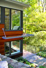 Reclaimed wood siding of “sinker cypress” and “pickle-tank fir” creates a connection to the forested setting.  A deck with stainless steel rods connects the front of house to the back yard.