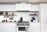 Kitchen, Metal Cabinet, Microwave, Engineered Quartz Counter, Refrigerator, Recessed Lighting, Range, Undermount Sink, White Cabinet, Range Hood, and Light Hardwood Floor  Photo 9 of 17 in Mill Valley Residence by Diego Pacheco Design Practice