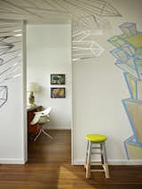 A mural, commissioned by artist Chris Buening, evolves over time. It frames the entry to a small office.