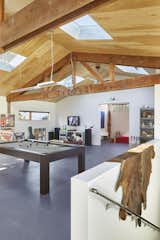 Great Room – The original wood roof trusses are exposed and refinished. The newly vaulted plywood-clad ceiling creates a warm contrast to the crisp white walls. The flooring is painted plywood. 