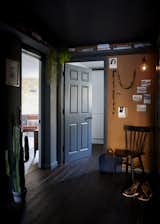 The entrance hall, with bamboo flooring, dark grey paintwork, and a cork wall for added texture.