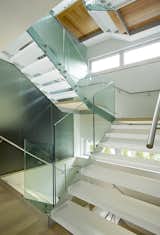 An open stair with acrylic treads and glass rails winds from the basement to the third floor, channeling natural light down through the home and connecting all the levels.