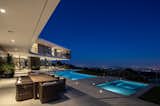 For the client's entertaining needs, the outdoor area includes a kitchen, two patios complete with fire pits, and an LED-lit pool1. The main garage also serves as an event space and can be completely opened on two sides for through views.