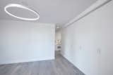 Living Room, Pendant Lighting, and Medium Hardwood Floor  Photo 8 of 9 in White on White Apartment by Andrew Mikhael Architect
