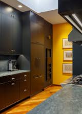 Black cabinet kitchen with soapstone countertop and backsplash