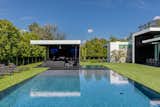 The backyard features an artificial lawn and a pool that comes right up to the grass' edge.  Photo 11 of 16 in Ponce Davis Residence by Choeff Levy Fischman