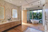 The master bath features dual vanities, a stand-alone tub, and a glass-enclosed shower.