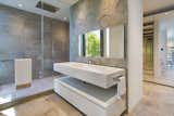 This bathroom features an expansive glass-enclosed shower and unique concrete stamped wall.  Photo 13 of 15 in Rivo Alto Residence by Choeff Levy Fischman