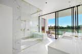 Master bathroom with glass-enclosed marble shower and separate tub with views of the outdoors.