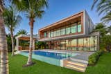The outdoor deck is surrounded by tropical grounds and features an infinity-edge pool with a spa and a cabana with an outdoor kitchen and dining area.