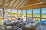 A spacious three-sided screened porch, conveniently located adjacent to the living/dining/kitchen area, is nestled on the edge of a dune overlooking the refreshing waters of Cape Cod Bay.