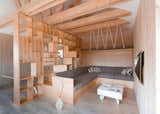 Russian-based studio Ruetemple conjured a plywood partition that  separates working and relaxation areas inside this artist's studio in Moscow, incorporating both furniture and shelves for tidying away art supplies.