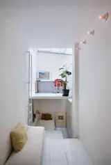 Tiny Madrid apartment by MYCC houses living and working spaces — rooms  connected by a ladder and stairs inserted in a single tall, narrow space.