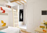 Bedroom with a ladder leading to a loft workspace.