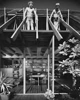 In this photo of the Diamond Street House taken by Julius Shulman, Brock Lyster (left) stands next to his brother on his father's roof truss.&nbsp;