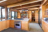 Kitchen, Range, Wood Cabinet, Granite Counter, Concrete Floor, and Pendant Lighting  Photo 11 of 13 in A 1974 Masterpiece Is Put on the Market by a Family Friend of the Late Julius Shulman