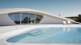 Large, Back Yard, Concrete, Large, Exterior, Stucco, and House  Exterior Large House Photos from This Y-Shaped Greek Villa Looks Like a Flying Saucer That’s Embedded Into the Hills