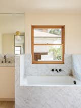 Bath, Marble, Soaking, Light Hardwood, Undermount, and Wall  Bath Light Hardwood Marble Soaking Undermount Photos from Grids and Colors Inspire the Renovation of a Graphic Designer's Pink L.A. Bungalow