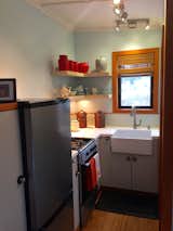 Full kitchen with refrigerator / freezer, stove / oven, farmers sink, open and closed storage. Bath, with sink, composting toilet and shower to right of sink.