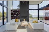 Double-height living room with wrap-around terrace, capturing ocean views between neighboring homes.