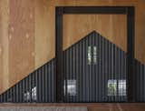 Agate Pass Cabin | Custom perforated corrugated zinc acts as a transparent curtain between rooms.