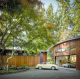 "The adjacent detached garage continues the home’s sculptural language with a curving roofline and high windows," says architect Olson Kundig. Inside, vaulted ceilings further echo the bright and airy interior of the home’s main living space. The garage provides an open workspace that supports the owner’s passion for restoring classic cars, as well as weather-protected storage. Just outside, a defined entry and forecourt create a multipurpose, functional space for both parking and play.