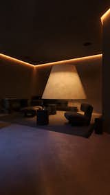 Soft ambient lighting enhances the cozy lounge with minimalist seating and a unique, oversized lamp.

#EO3H #sirotovarchitects #cozyinterior