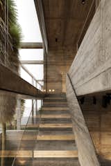 A modern staircase design featuring raw concrete textures and large glass panels that bring in natural light, creating a dynamic, industrial look. #mb3h #interiordesign #staircase #concrete