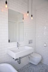 Unique fixtures, wall hung toilet and a modern Robern mirror maximized space in this small bathroom.