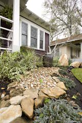 Boulders, a water feature and a river path were created in the front yard to enhance the asian flair this home had.  Landscape lighting was installed to ensure that the home felt warm even at night.