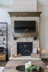 Custom stone fireplace with custom wood beam mantle located in great room