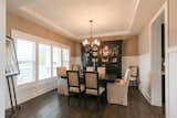 Elegant dining room with custom wainscoting and stepped ceiling detail 