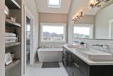 Luxury Master Bath with Stand Alone Soaking Tub, Custom Exposed Shelving Detail, and Custom Above Mounted His and Her Sinks.