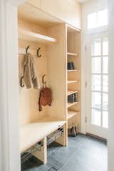 Side door entry turned into a mudroom to accommodate a family of four. We had all custom cabinetry made with the same Ash wood as the kitchen and living room. Custom hardware made from a seller on etsy. The light Ash wood off sets the new dark floor tile. Interior Designer: Sage Market + Design. Cabinets: Cronin Cabinetry.