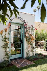 A new arched doorway framed by a delicate flower trellis creates a lush, storybook vignette.