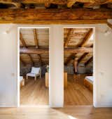 The bedrooms feature stone walls and rustic timber ceilings that slope toward the floor.