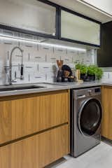 The integrated laundry area under the kitchen counter offers a smart space-saving solution.