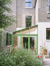 <span style="font-family: Theinhardt, -apple-system, BlinkMacSystemFont, &quot;Segoe UI&quot;, Roboto, Oxygen-Sans, Ubuntu, Cantarell, &quot;Helvetica Neue&quot;, sans-serif;">The frame introduces a pop of green-painted aluminum to differentiate the new glass house from the more traditional spaces inside.</span><span style="font-family: Theinhardt, -apple-system, BlinkMacSystemFont, &quot;Segoe UI&quot;, Roboto, Oxygen-Sans, Ubuntu, Cantarell, &quot;Helvetica Neue&quot;, sans-serif;"> </span>  Photo 18 of 18 in Extension by Jean-Vivier Lévesque from An Old London Victorian Gets a Greenhouse-Inspired Dining Room