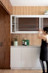 Leah selected light-diffusing sepia-toned reeded glass for some of the upper cabinets because "you can store anything inside and not see any distracting shapes or colors. It feels like old glass from an apothecary, and it ties together the warmth in the oak floor and walnut cabinetry."