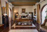 The main house showcases a great room with original gold-leaf ceiling panels and arched mahogany pocket doors, opening the entire home to the gardens and fountains.