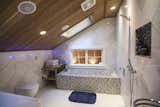 Upstairs the combined wet room and bathroom includes a hand built six feet long soaking tub with a river stone surface. The ceiling is cedar wood.