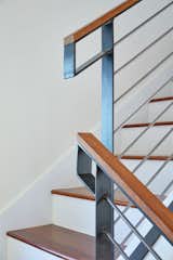 A custom fabricated steel guardrail with an ipe cap by Brian Chilton Design, continues the angular lines found throughout the small house