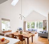 Living Room - The large, open living room melds seamlessly into the dining room and kitchen - allowing the occupants to spread out while staying connected to each other. Big expanses of glass link the interior with the neighborhood outside and keep the space bright; while vaulted ceilings give the room a sense of grandeur.