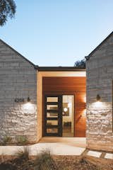 Front Door - The entry acts as a tendon between the two wings of the house. Linear bands of wood express this temporal connection between the two stone gables.