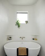 Curved walls in the wetroom hug the tub