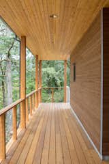 The covered walkway is enveloped by cedar planks and lush oak canopies.