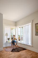 A reading nook, furnished with corner casement windows, welcomes an unexpected guest.