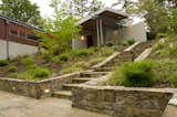 Low basalt stone walls lead to the home's entry at the upper terrace. 