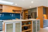 Glass cabinet doors on the back of the island make for great storage, and fir shelves in between can showcase the finer art.